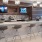 a lounge with a tv and stools